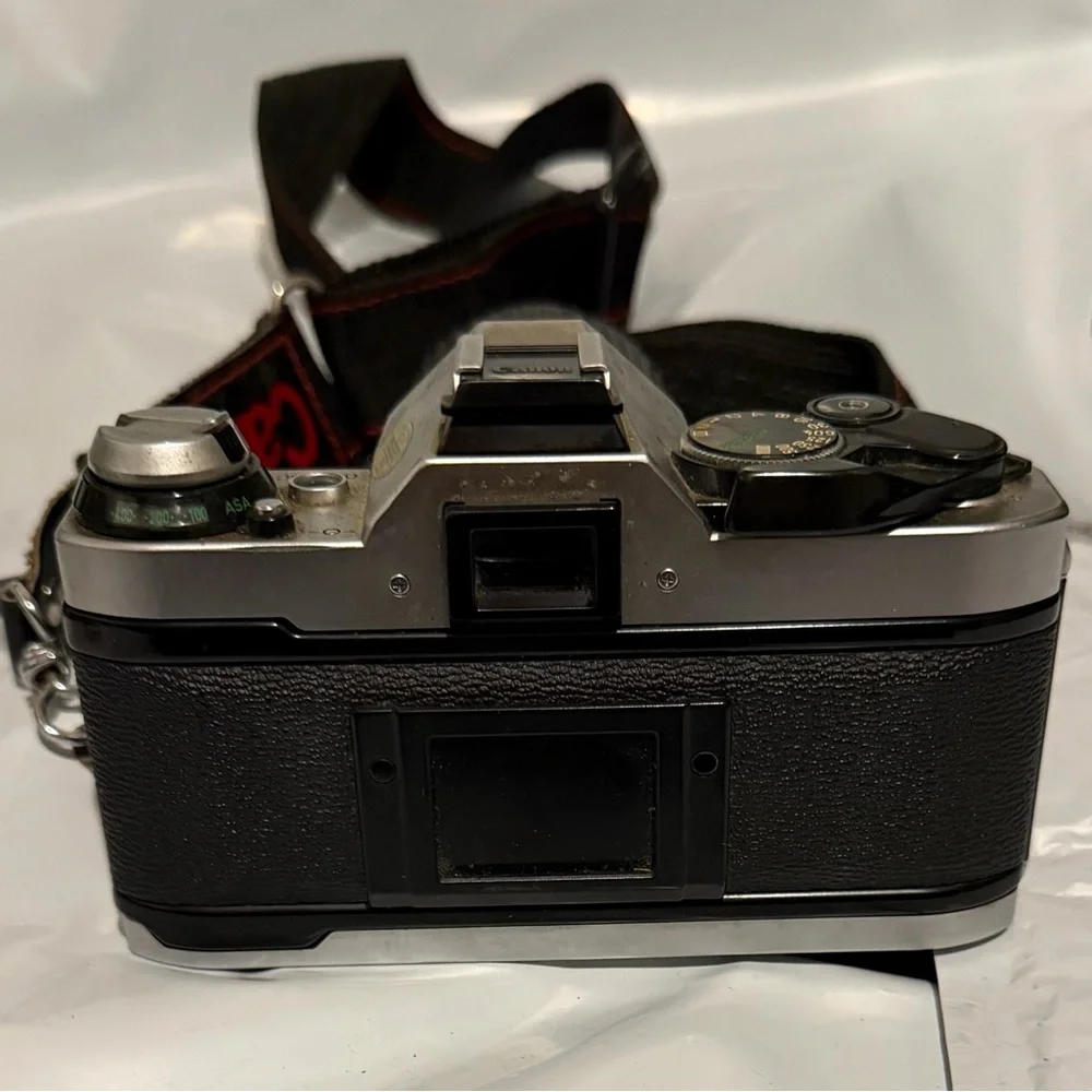 Canon silver and black SLR camera with black telephoto lens